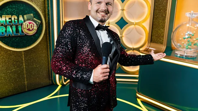 Carátula de Mega Ball con un presentador junto a una máquina de bolillas.